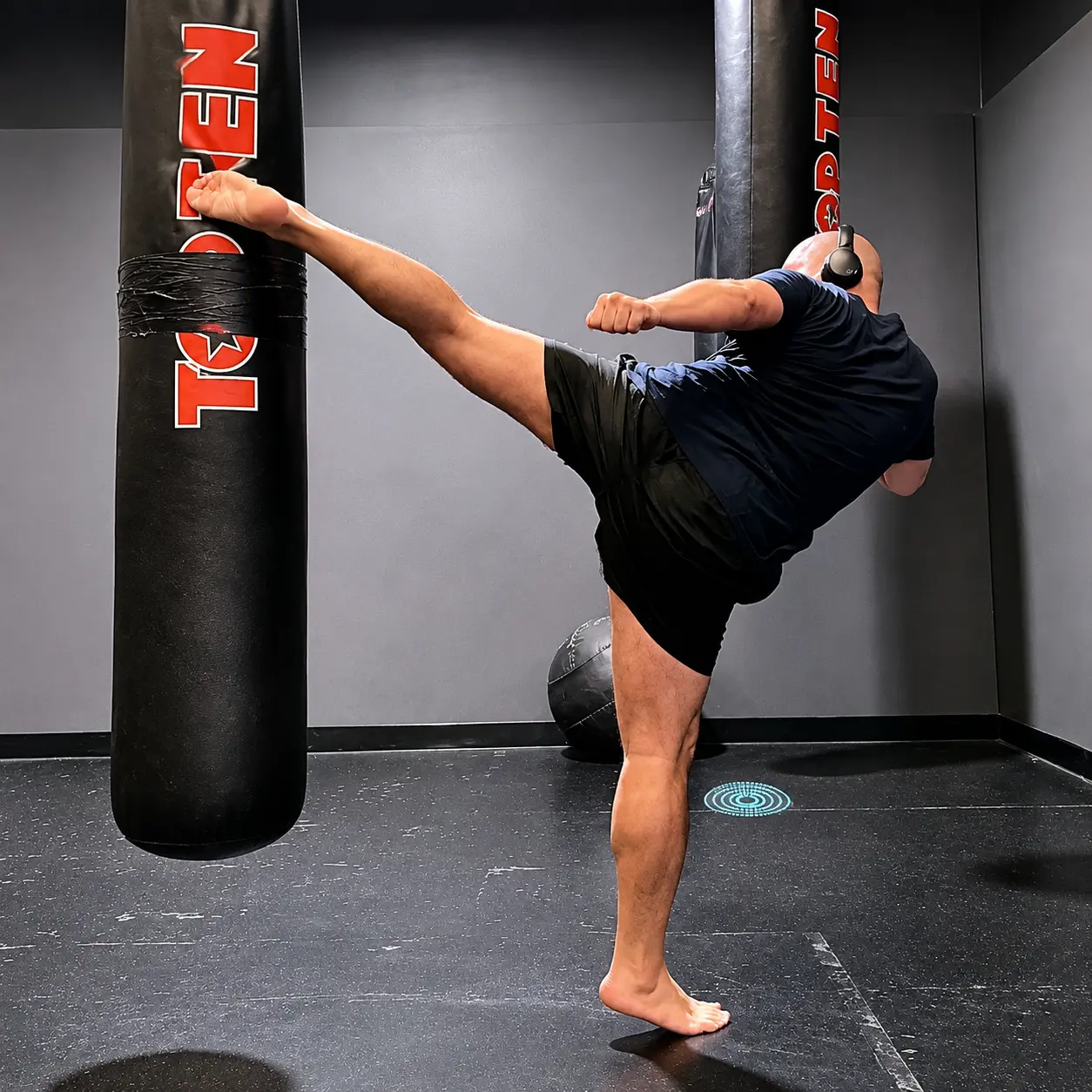 Olgun Tiltay training round kicks on the bag